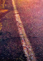 Close up of worn and cracked road in purple sunset tones, with pink, white, and orange road sparkle. 